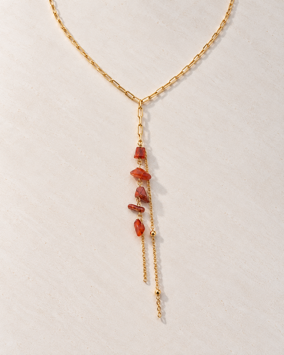 Collar Garance en Y con piedras cornalina sobre cemento blanco